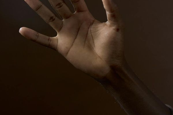 Silhouette of a person in a balanced pose against a simple background.